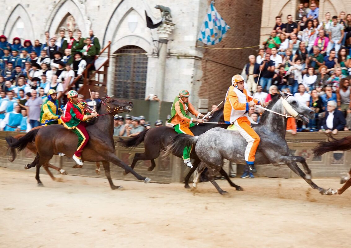 men riding horses in costume in Siena 