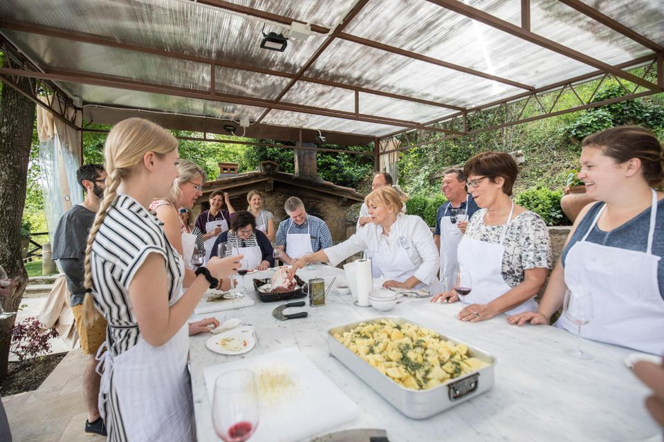 Best things to do in Tuscany - a group of people taking a cooking class