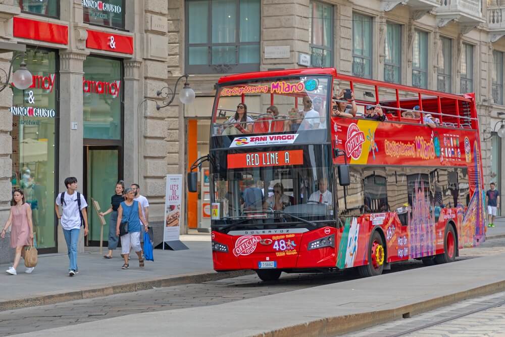 Red double decker bus on the street in Milan